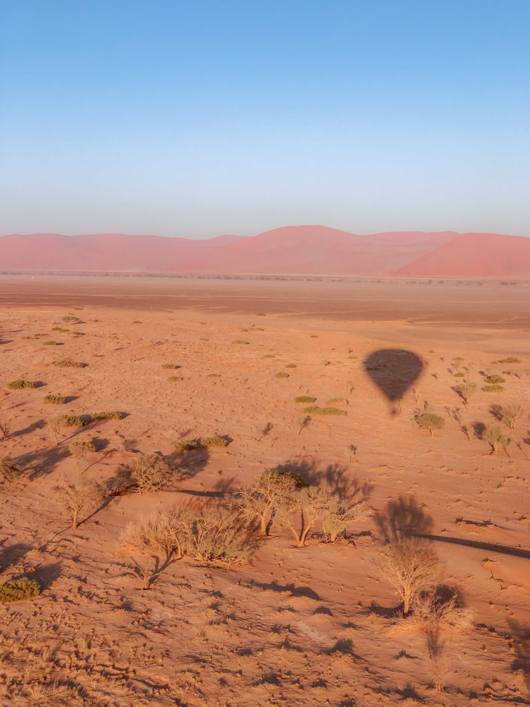 hot air balloon shadow in desert namibia
